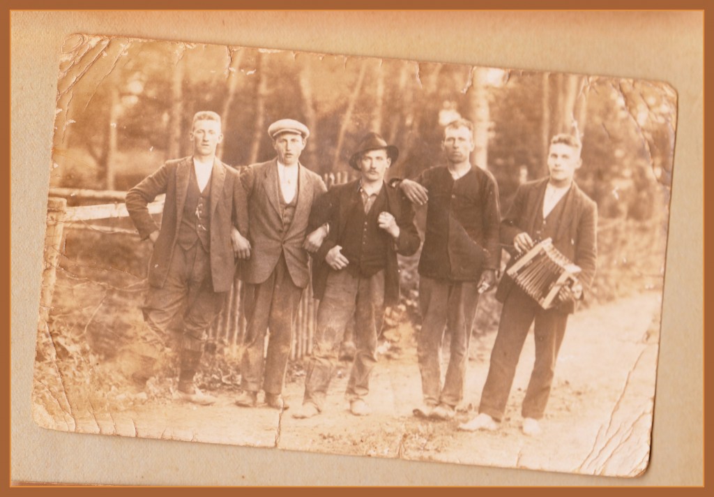 Ove Karlsen sammen med fire andre unge mænd, der står med hinanden i armene som en kæde. Den sidste mand har en lille harmonika med.